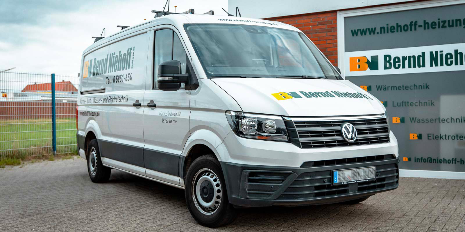 Im Vordergrund sieht man einen weißen Lieferwagen, der für Heizungs- und Elektrotechnikdienste von Bernd Niehoff wirbt.