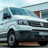 Ein moderner Lieferwagen in Weiß, der für die Firma Bernd Niehoff wirbt, steht vor einem Gebäude mit einem klaren, grauen Himmel im Hintergrund.
