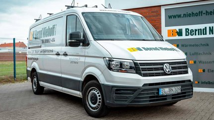 Im Vordergrund sieht man einen weißen Lieferwagen, der für Heizungs- und Elektrotechnikdienste von Bernd Niehoff wirbt.